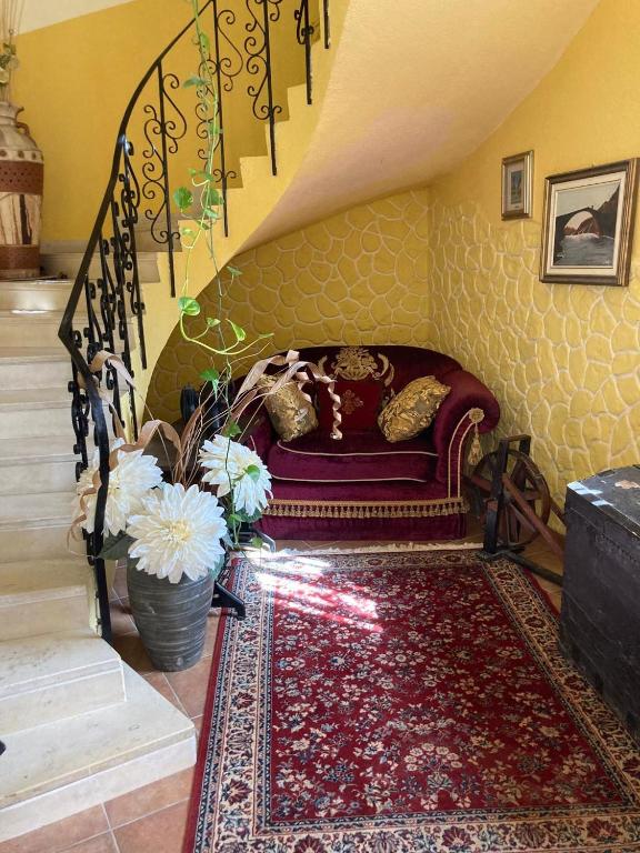 salon z czerwoną kanapą i schodami w obiekcie BLUE SEA w mieście Roccella Ionica
