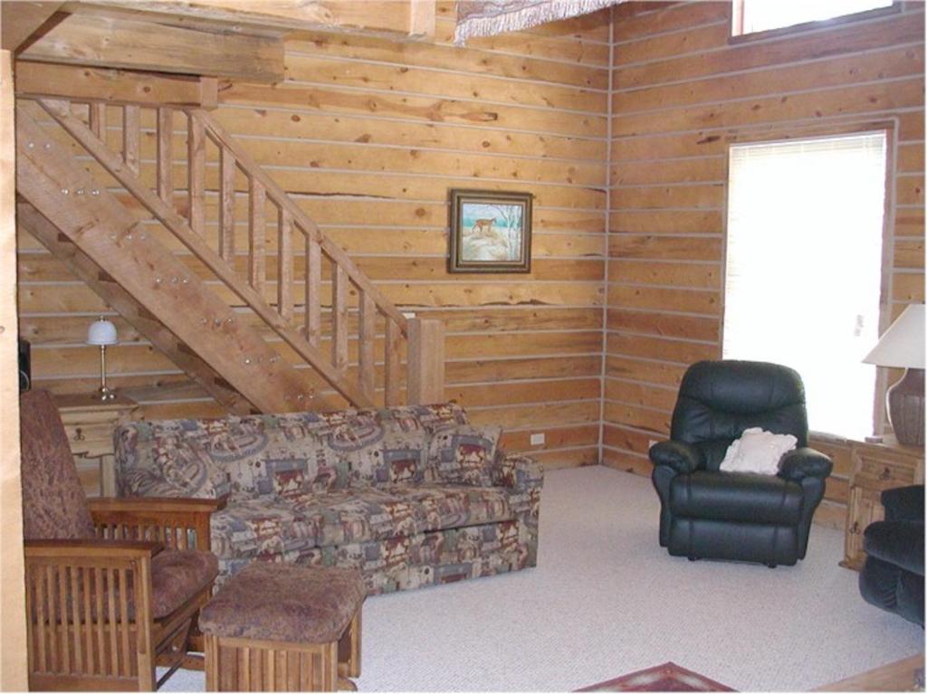 una sala de estar con sofá y sillas en una cabaña en Comanche Lodge, en Custer