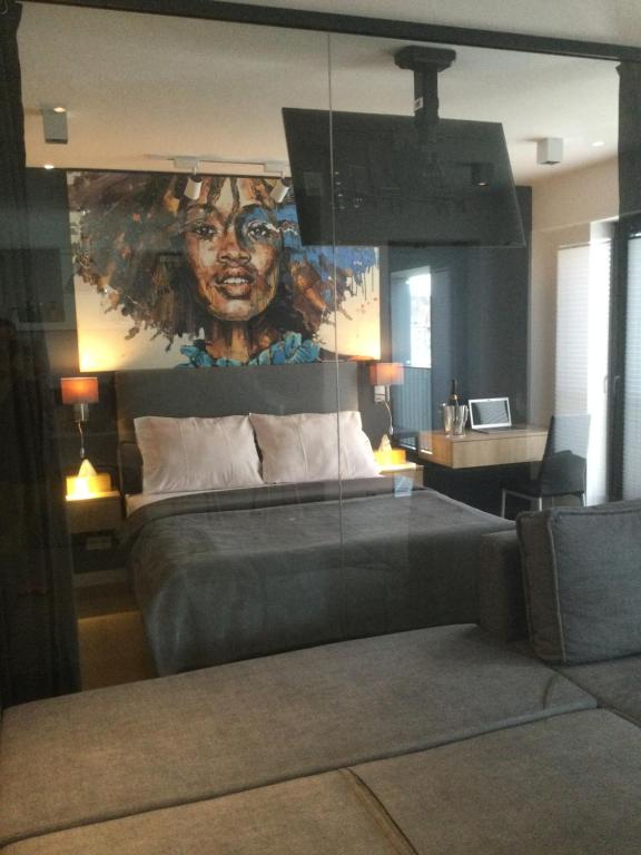 um quarto com uma cama com um quadro de uma mulher em Apartament EXCLUSIVE FYRTEL WILDA - NEW em Poznań