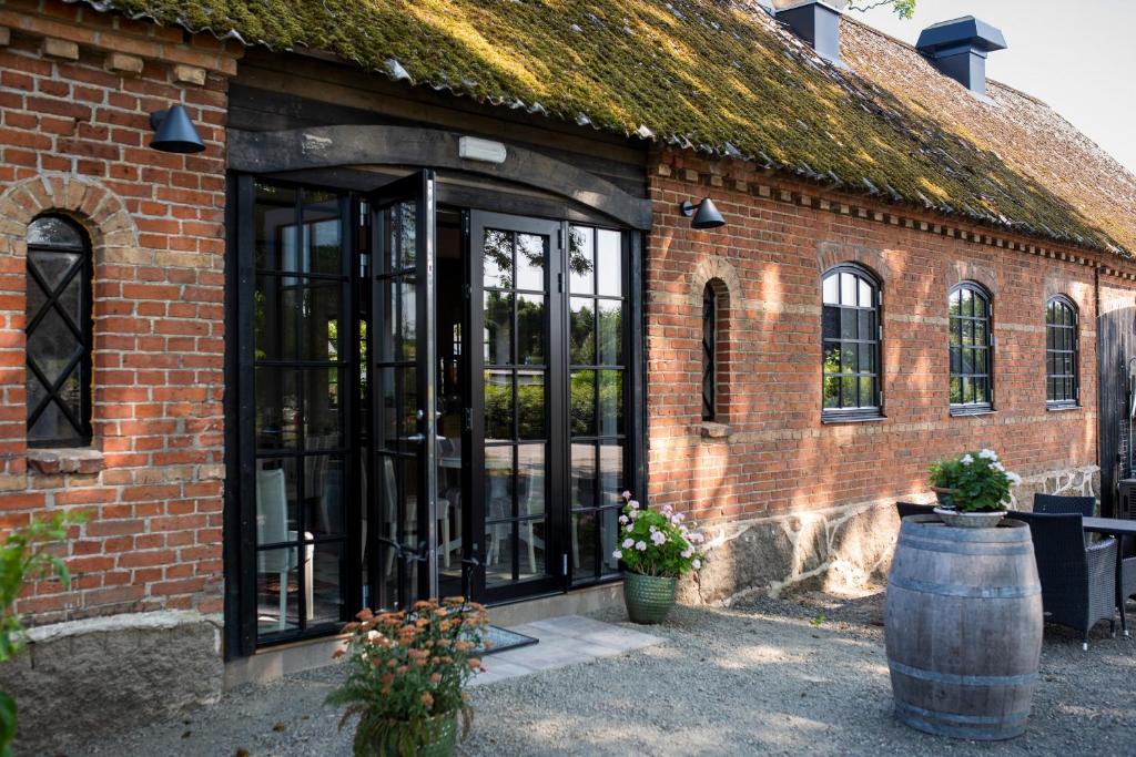 una entrada a un edificio de ladrillo con puertas de cristal en Rörums Gårdshotell, en Simrishamn