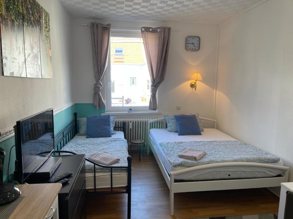Kleines Zimmer mit 2 Betten und einem Schreibtisch. in der Unterkunft Apartment in der Innenstadt in Göttingen