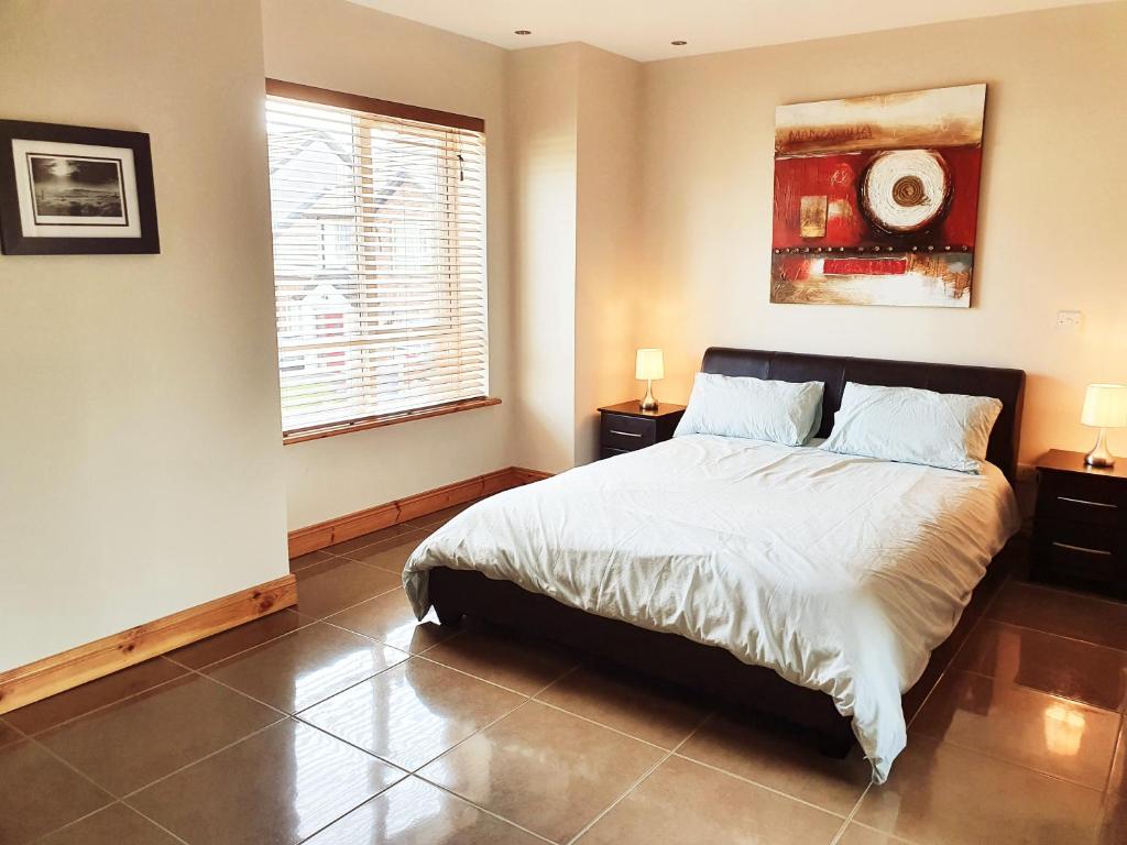 a bedroom with a large bed and a window at Seaview Apt in Buncrana with balcony in Buncrana