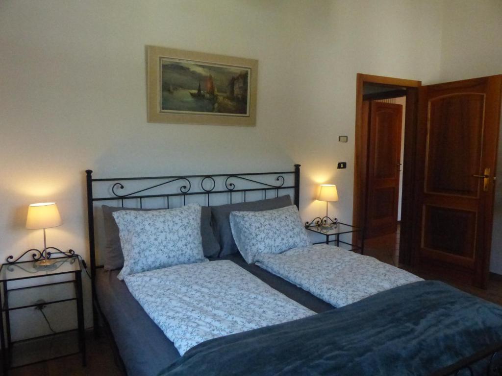 een slaapkamer met een bed met blauwe lakens en kussens bij Appartamento Trentino I in Comano