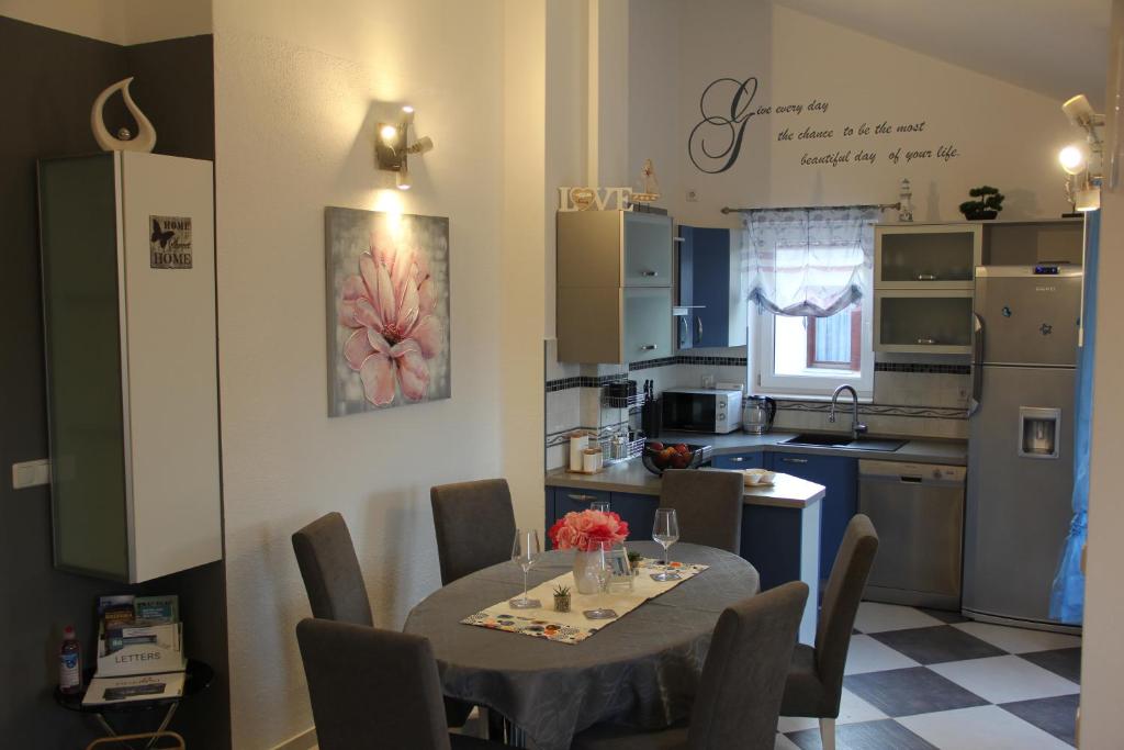 uma cozinha com uma mesa e cadeiras numa cozinha em Apartman Odin em Čižići