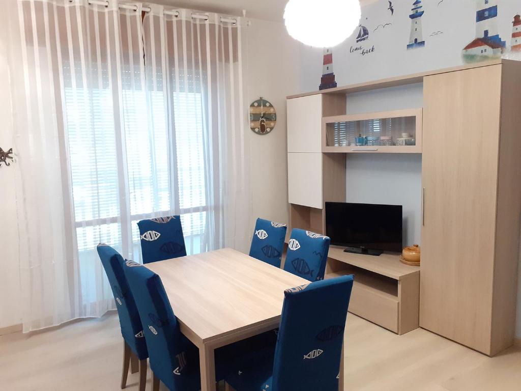uma sala de jantar com uma mesa de madeira e cadeiras azuis em I Velieri em Cesenatico
