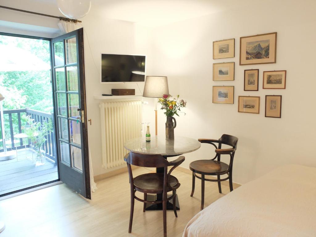 a room with a table and chairs and a bed at Ferienstudio-Apartment Tausendfreund "adults only" am Chiemsee in Breitbrunn am Chiemsee
