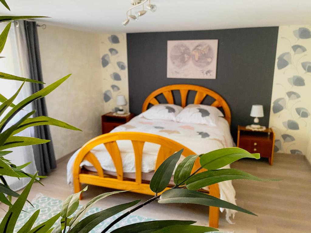 sypialnia z drewnianym łóżkiem i doniczką w obiekcie L'eau vive w mieście Ranspach