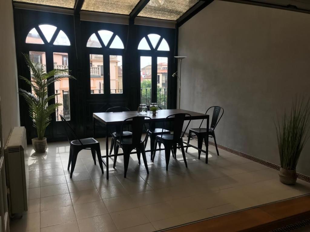 a dining room with a table and chairs and windows at Corrillo Suite Plaza Mayor - Parking opcional in Salamanca