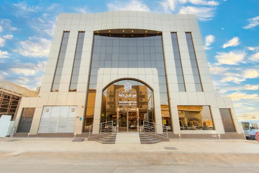 un grand bâtiment avec une entrée à un magasin dans l'établissement جولدن دلة للشقق المخدومة, à Buraydah