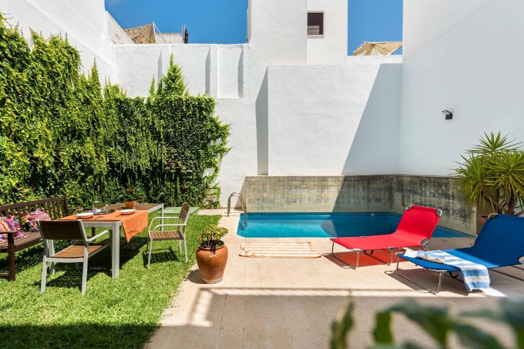 un patio con sillas y una piscina en AlohaMundi Triana, en Sevilla