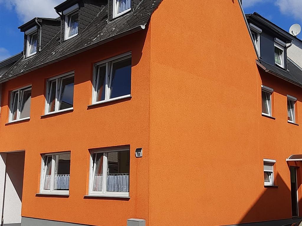 un bâtiment orange avec des fenêtres et un toit noir dans l'établissement Ferienwohnung Sabine, à Coblence