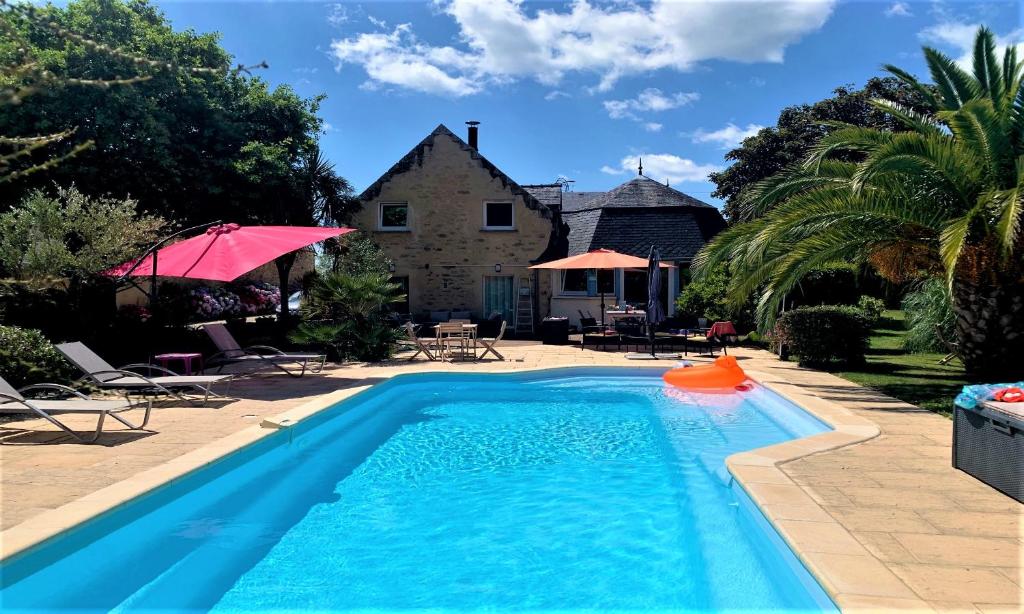 a swimming pool with a house in the background at Le Chêne in Névez