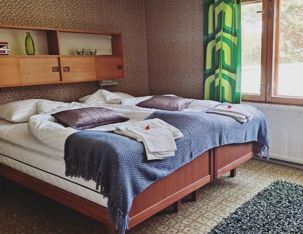 1 dormitorio con 2 camas y toallas. en Solvillan, en Korpo