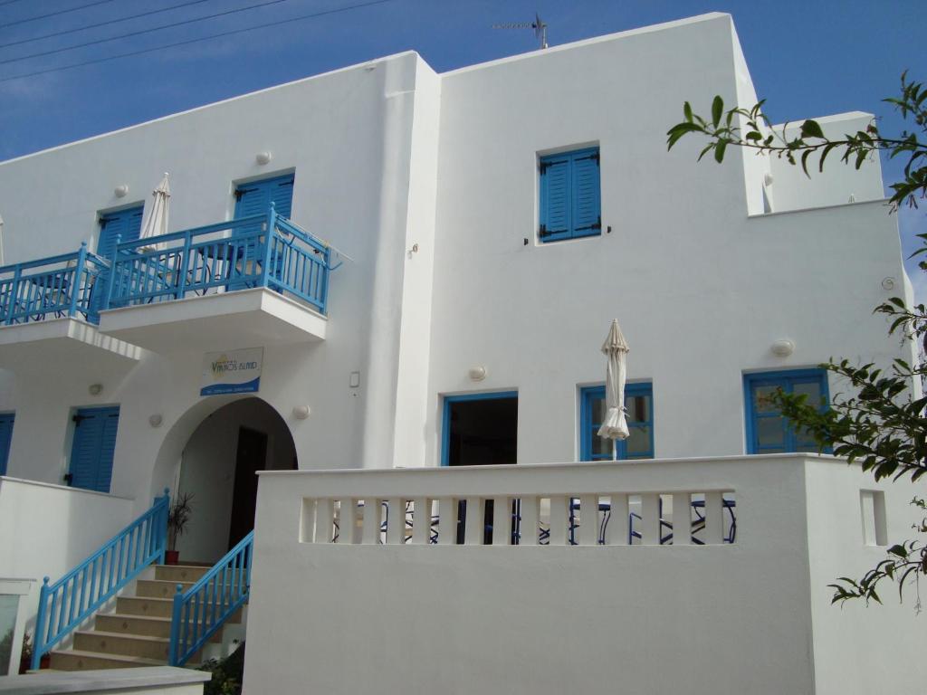 een wit huis met blauwe balkons en trappen bij Vakhos Island in Agia Anna Naxos