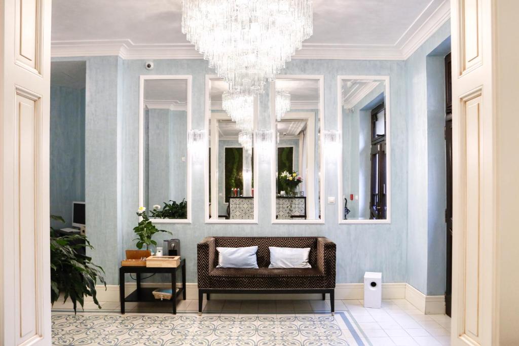 a living room with a chair and a chandelier at Ferdinandhof Apart-Hotel in Karlovy Vary