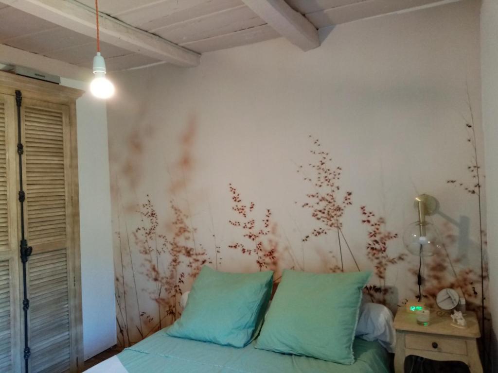 a bedroom with a bed with blue pillows at Echo du Maquis in Penta-Acquatella