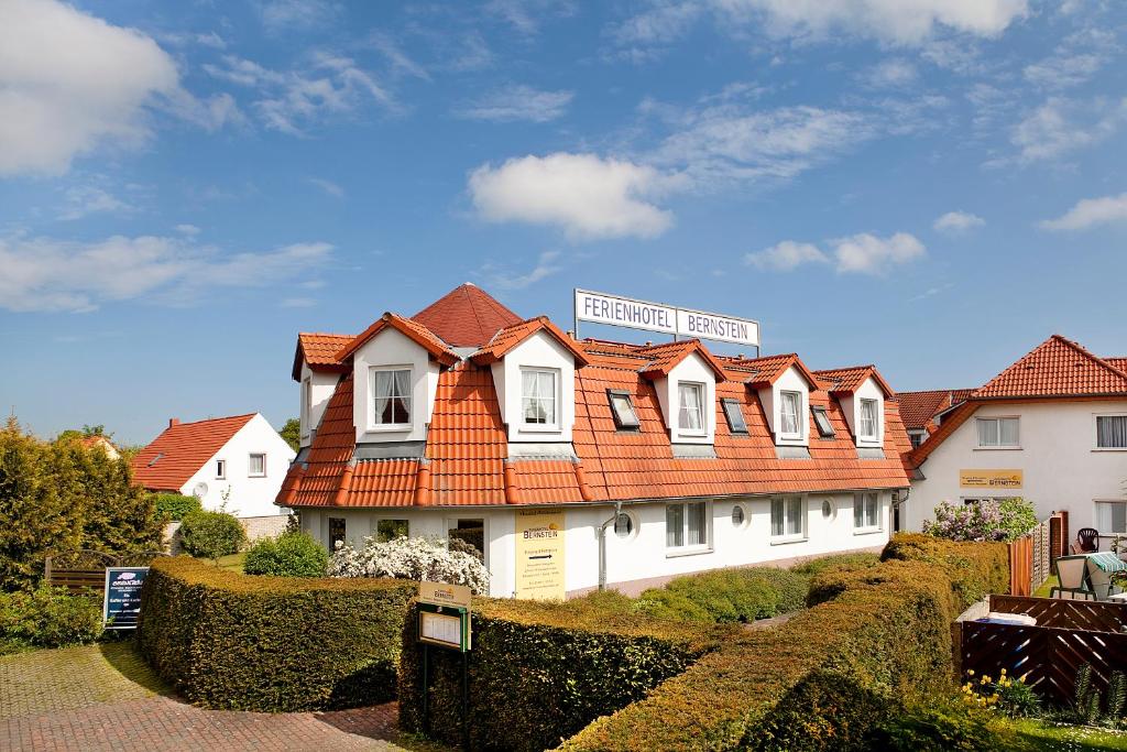 ein weißes Haus mit orangefarbenem Dach in der Unterkunft Ferienhotel Bernstein in Trassenheide