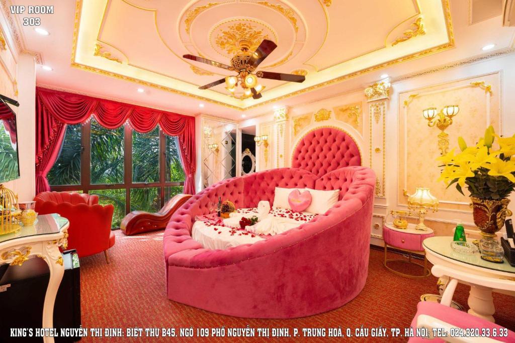 a room with a large pink couch in a room at King's Hotel Nguyễn Thị Định in Hanoi