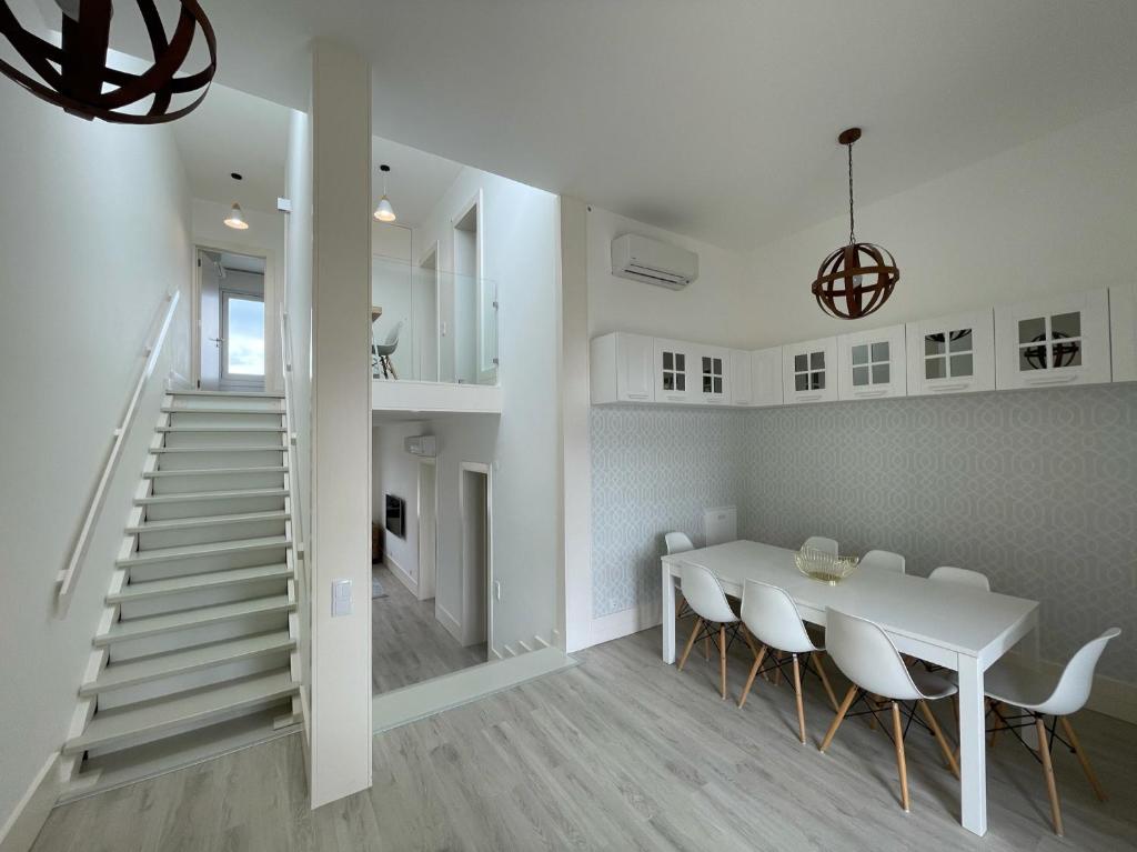 un comedor blanco con una mesa y sillas blancas en Beautiful Penthouse Apartment With Terrace - 4 Minute Walk to the Beach, en Tróia