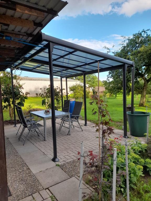 a pergola with a table and chairs on a patio at Haus Wald und Wiese Wohnung Wiese in Ehndorf