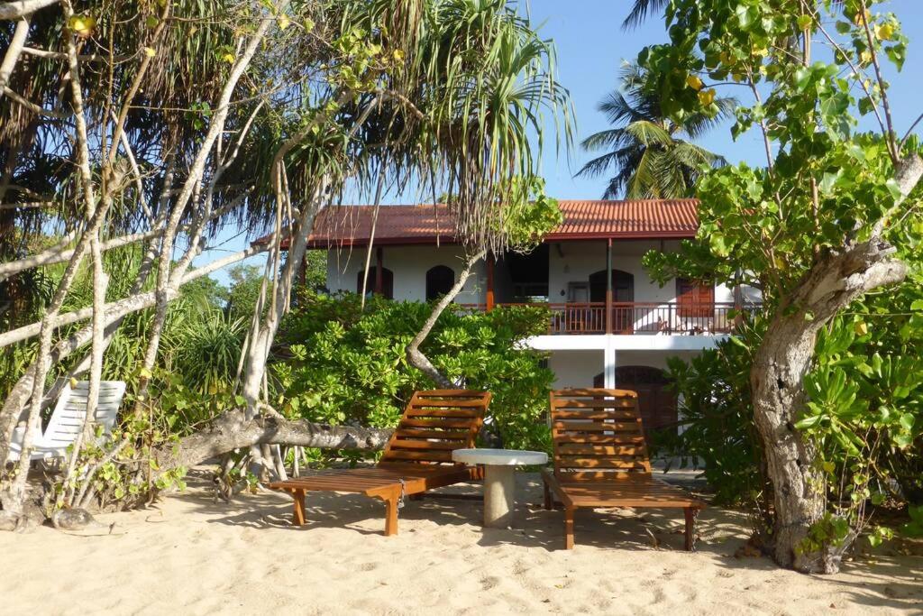 two chairs and a table in front of a house at Villa Sunrise Ferienhaus in Tangalle
