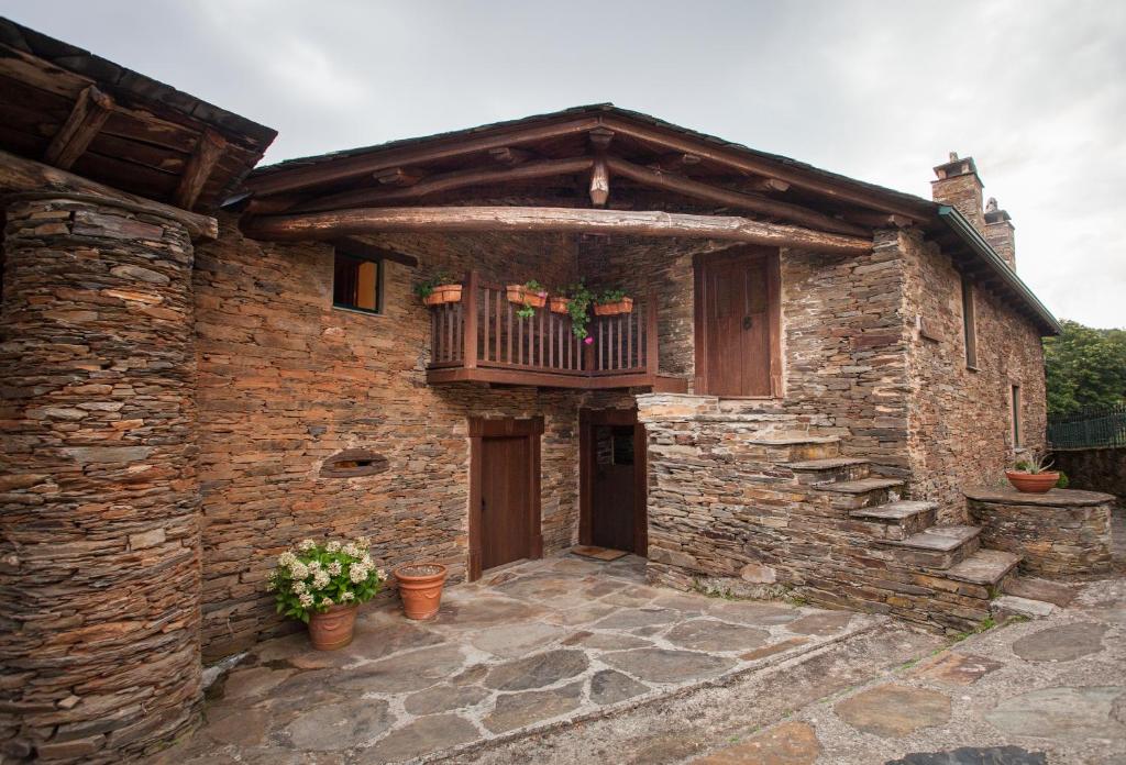 a stone house with a balcony and a porch at CASA XAYMACA in Samos