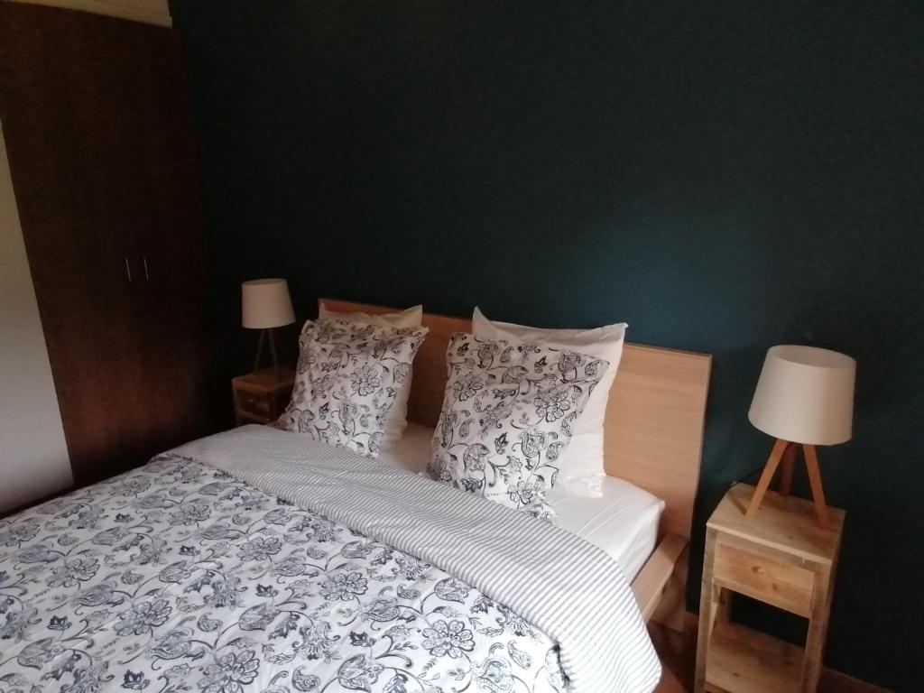 - une chambre dotée d'un lit avec des draps et des oreillers blancs et gris dans l'établissement Bienvenue en Gaume !, à Izel