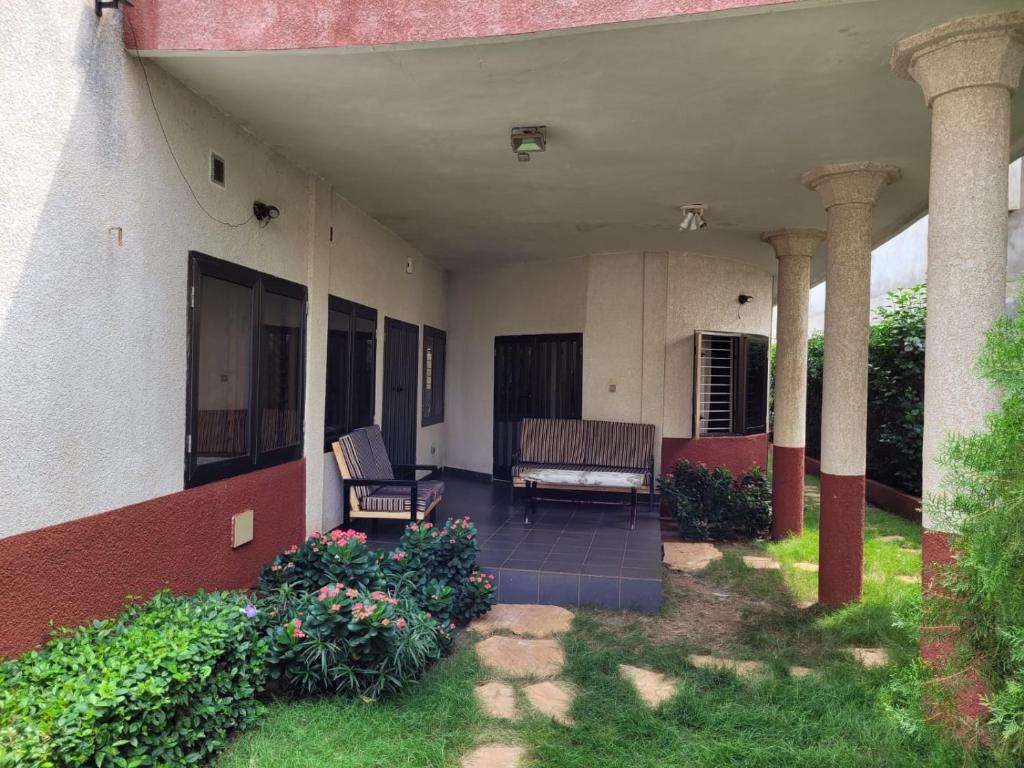 eine Veranda eines Hauses mit zwei Stühlen und Blumen in der Unterkunft Villa Anaël in Porto-Novo