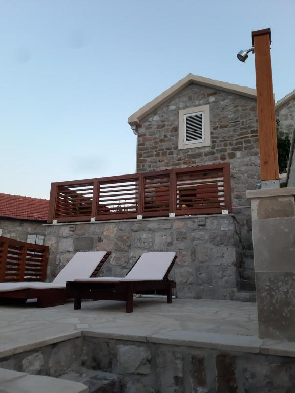 two benches sitting on a patio in front of a building at Apartman Hana in Tivat