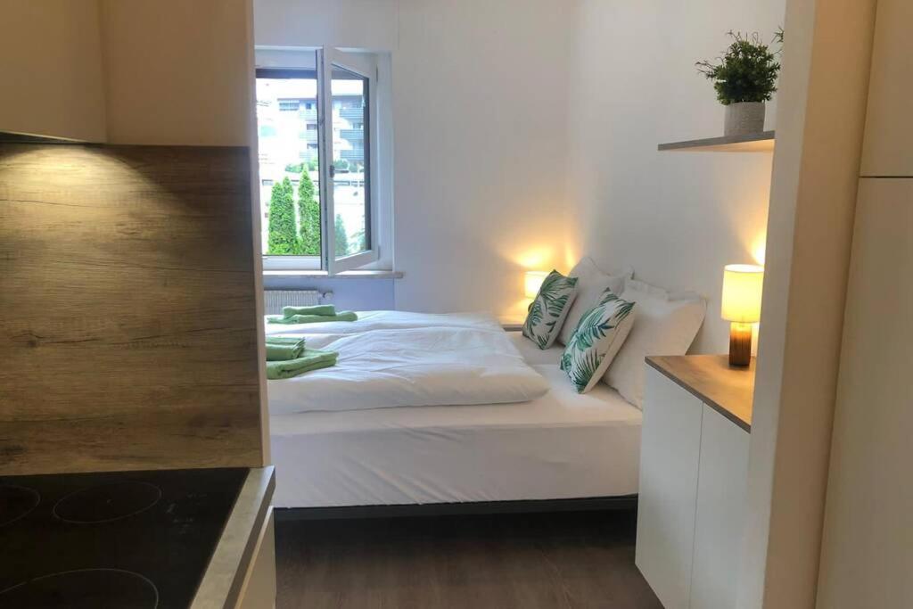 een slaapkamer met een wit bed en een raam bij Brunico 19 in Brunico