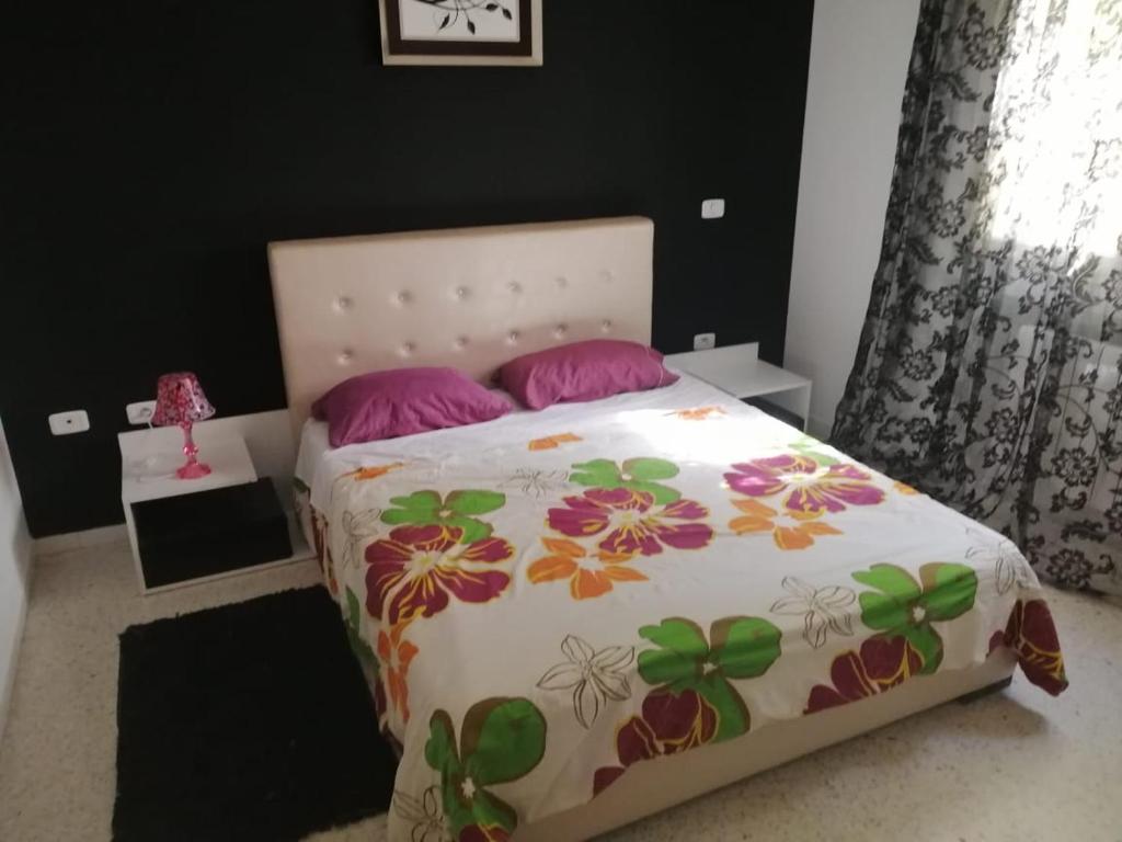 El Aouinaにあるrésidence les jardinsのベッドルーム1室(ピンクの枕が付いたベッド1台付)