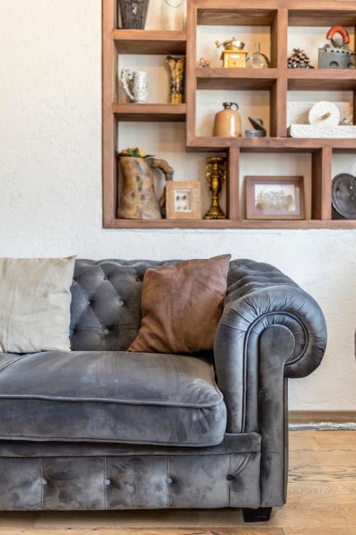 a leather couch in a living room with shelves at Villa Grey Stone in Gata