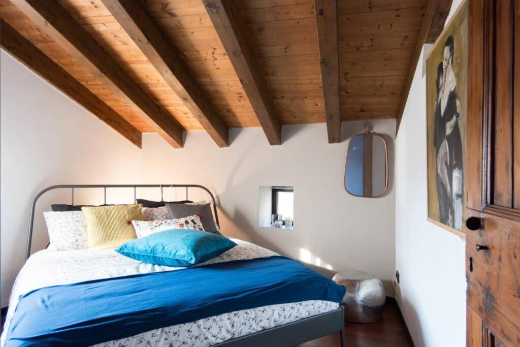 una camera da letto con letto con lenzuola blu e soffitti in legno di Ca' Pescheria a Treviso