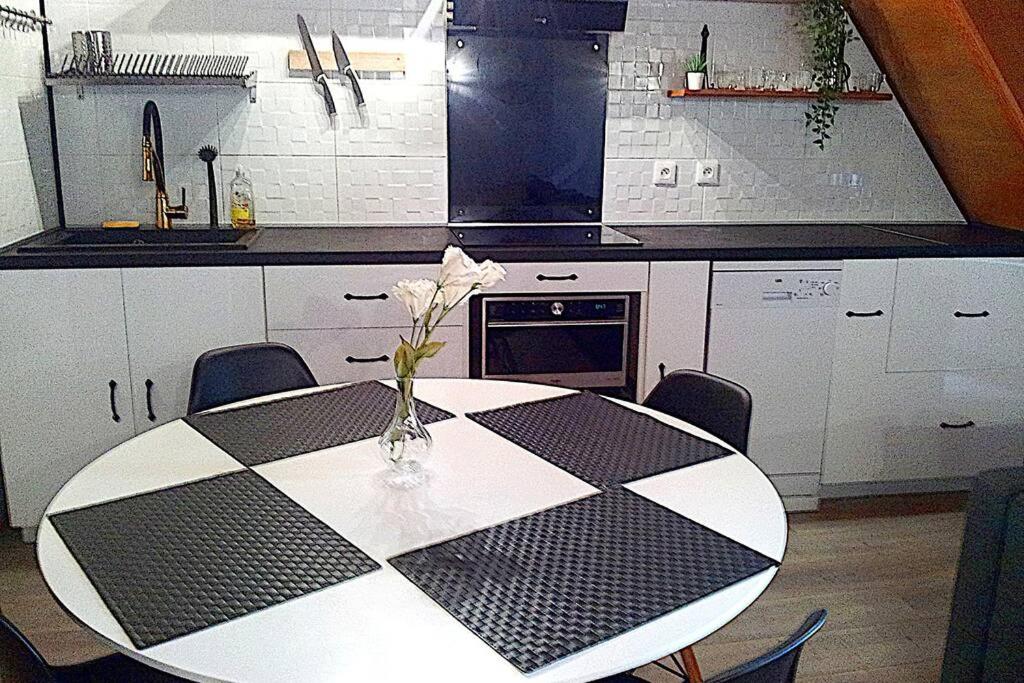 eine Küche mit einem Tisch und einer Blumenvase darauf in der Unterkunft Appartement en duplex - tout confort plein-centre in Lavaur