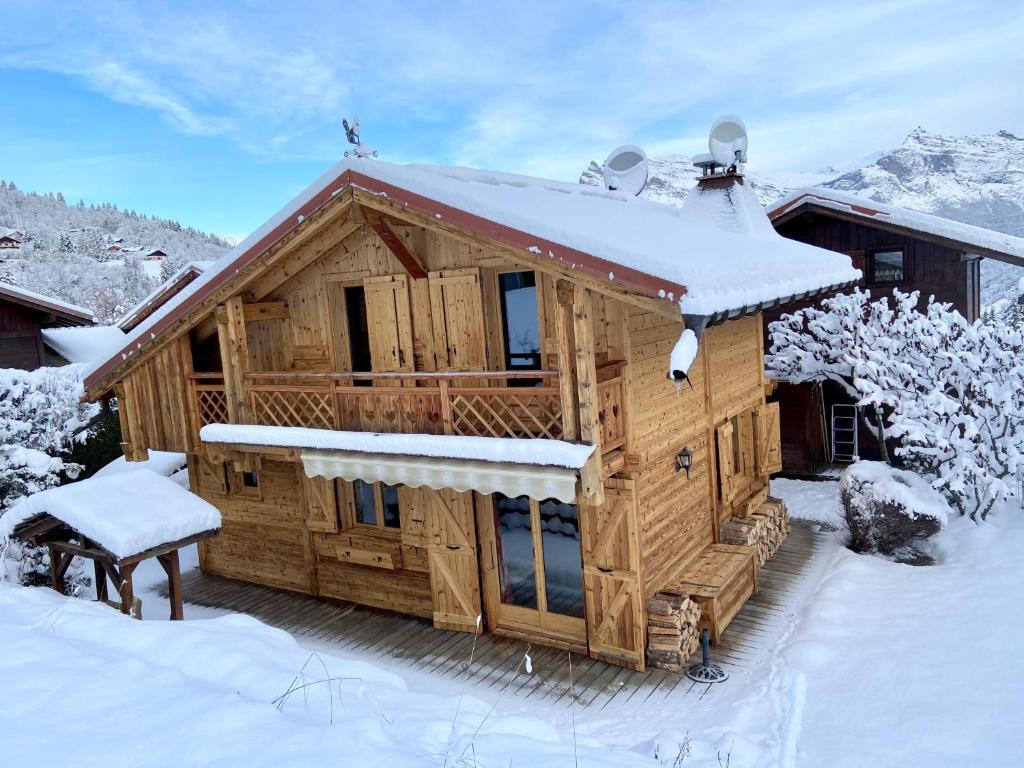 une cabane en rondins avec de la neige sur le toit dans l'établissement Chalet massif du Mont Blanc St Gervais Megeve, à Saint-Gervais-les-Bains