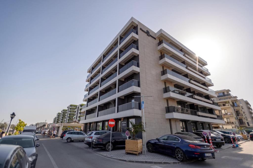 un estacionamiento con autos estacionados frente a un edificio en Plazza Mamaia Nord en Mamaia-Sat