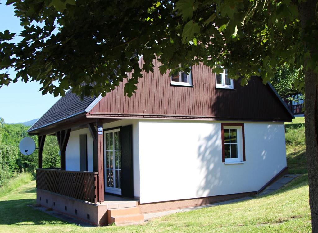 een klein wit huis met een rood dak bij Chata Větrník u Černého dolu v Krkonoších in Lauterwasser