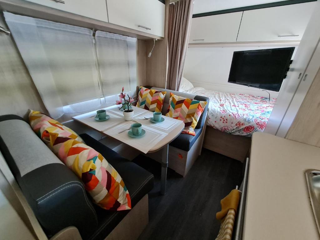 a small room with a table and a bed at Caravane tractable in Paliseul