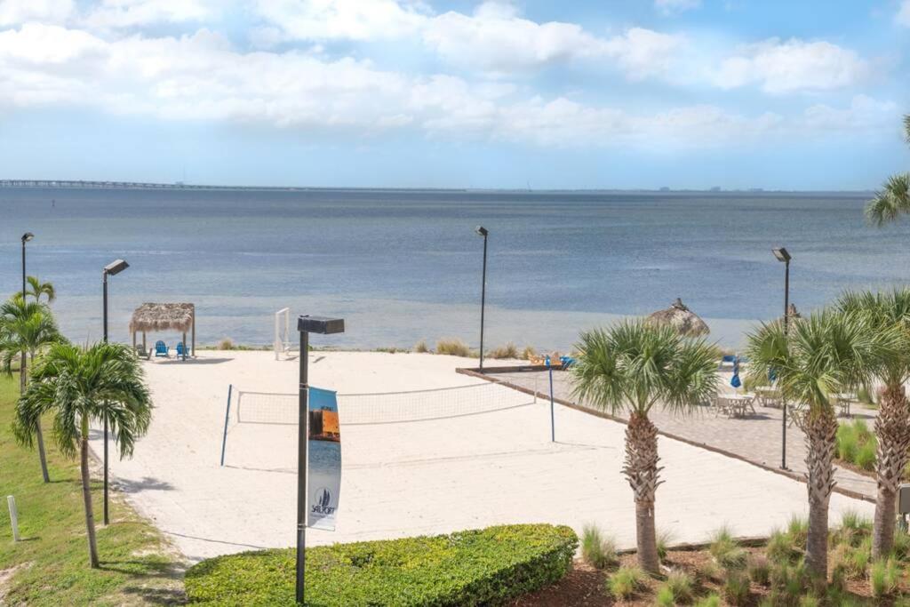 a volleyball court on the beach with palm trees and the ocean at 311-Mermaids condo in Tampa