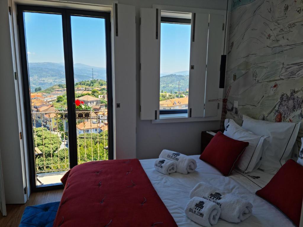 una camera da letto con un grande letto con asciugamani di Casa da Zéfinha, em Cinfães, no Douro a Cinfães
