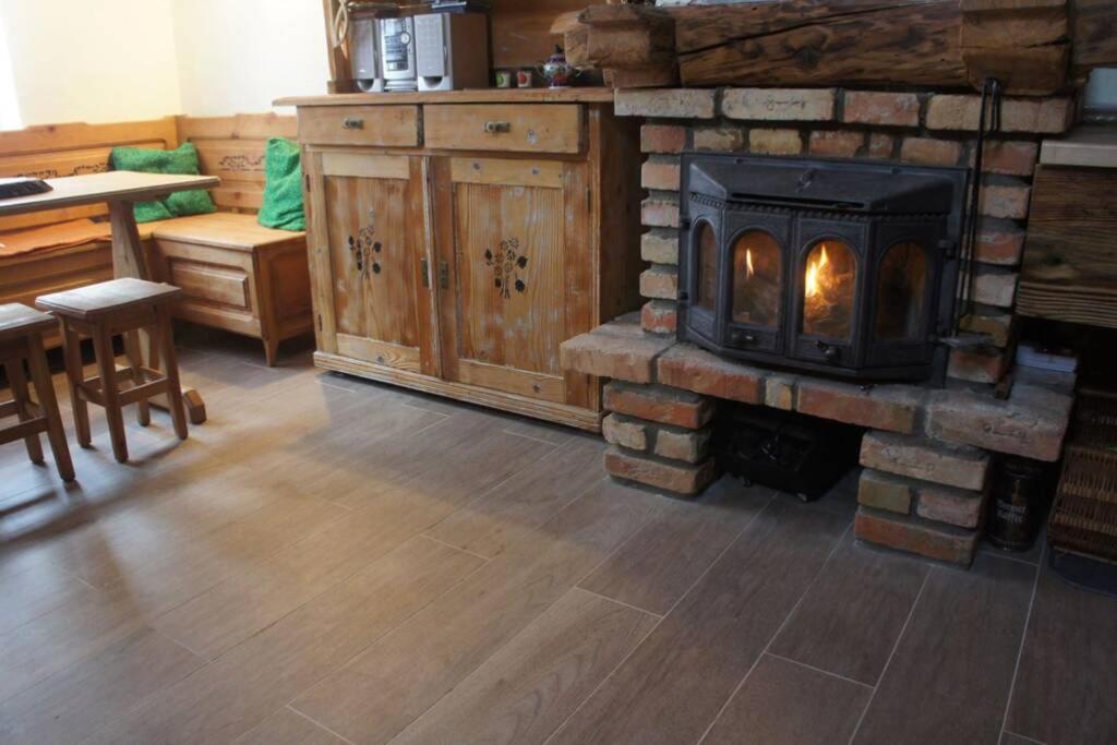 a living room with a fireplace and a stove at Agroturystyka Ropienka in Ropienka