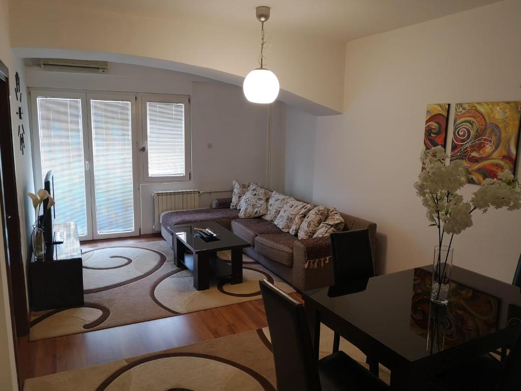 a living room with a couch and a table at Hello Apartment in Skopje