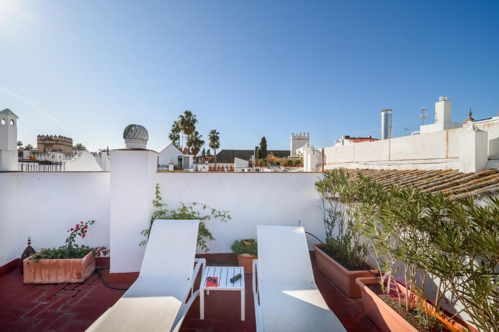 een balkon met stoelen en planten in een gebouw bij Apartamentos Boutique Vida in Sevilla