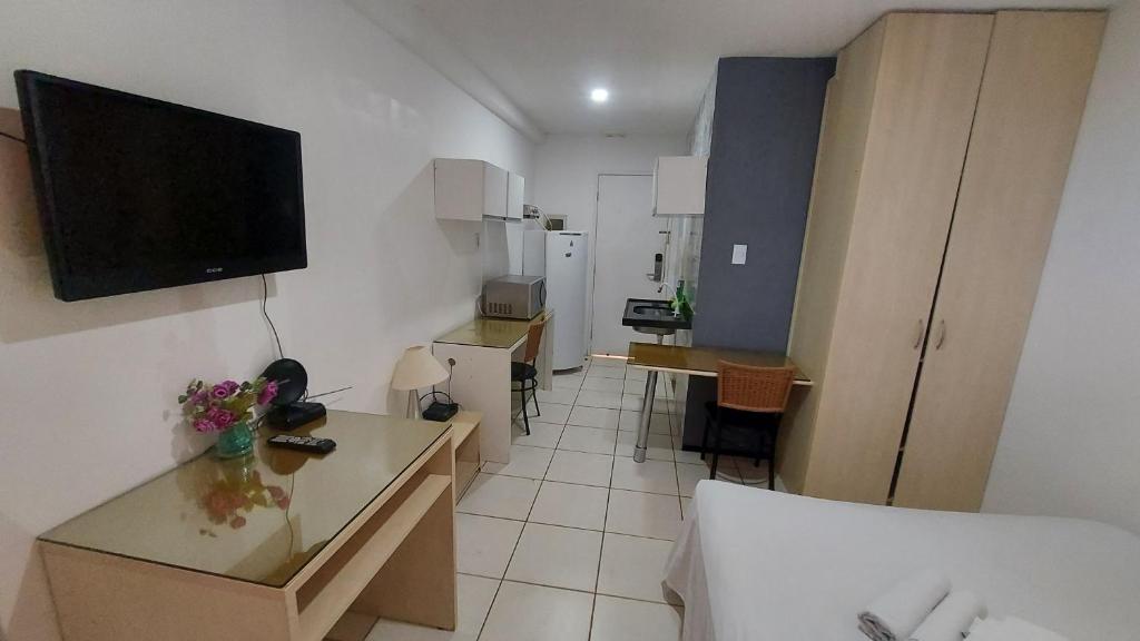 a small room with a bed and a television on the wall at Flat Bellagio - suítes econômicas - Ferreira Hospedagens in São Luís