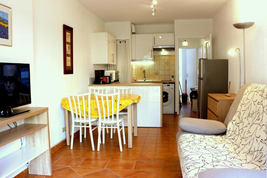 a kitchen and living room with a table and chairs at T2 Terrasse, Bormes Les Mimosas La Faviere, 5 mn à pieds des plages et commerces in Bormes-les-Mimosas