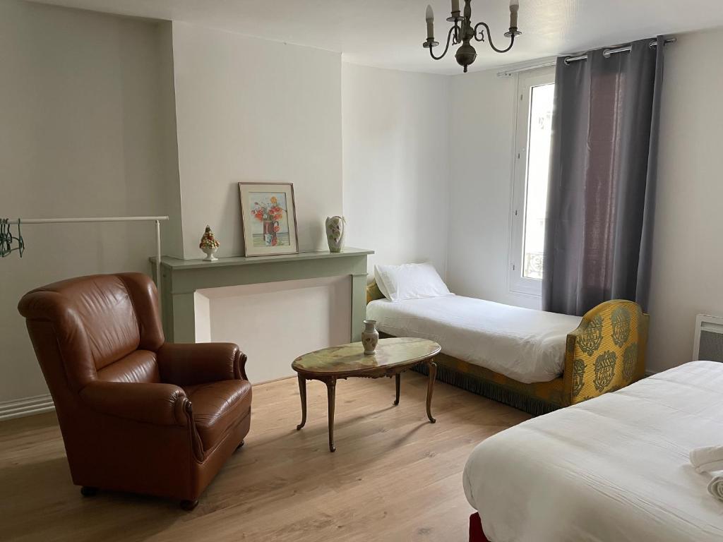 um quarto com duas camas e uma cadeira e uma mesa em Gîtes des châteaux : gîte C em Selles-sur-Cher