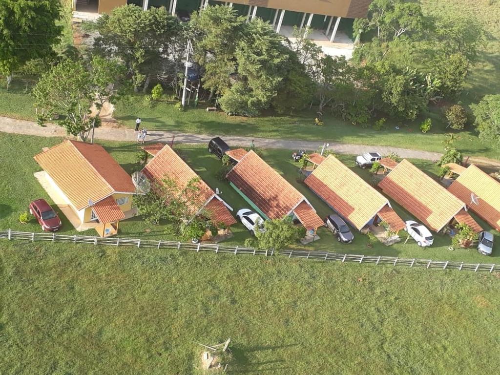 a row of houses with cars parked in the grass at Pousada Chalés da Estalagem in São Bento do Sapucaí