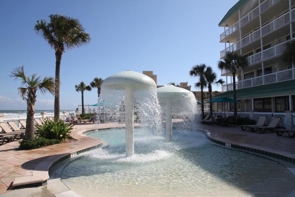 une fontaine au milieu d'une piscine dans un complexe dans l'établissement Oceanview Studio, à Daytona Beach