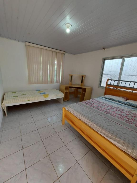 um quarto com duas camas e uma mesa em Aluga-se por temporada em Vitória