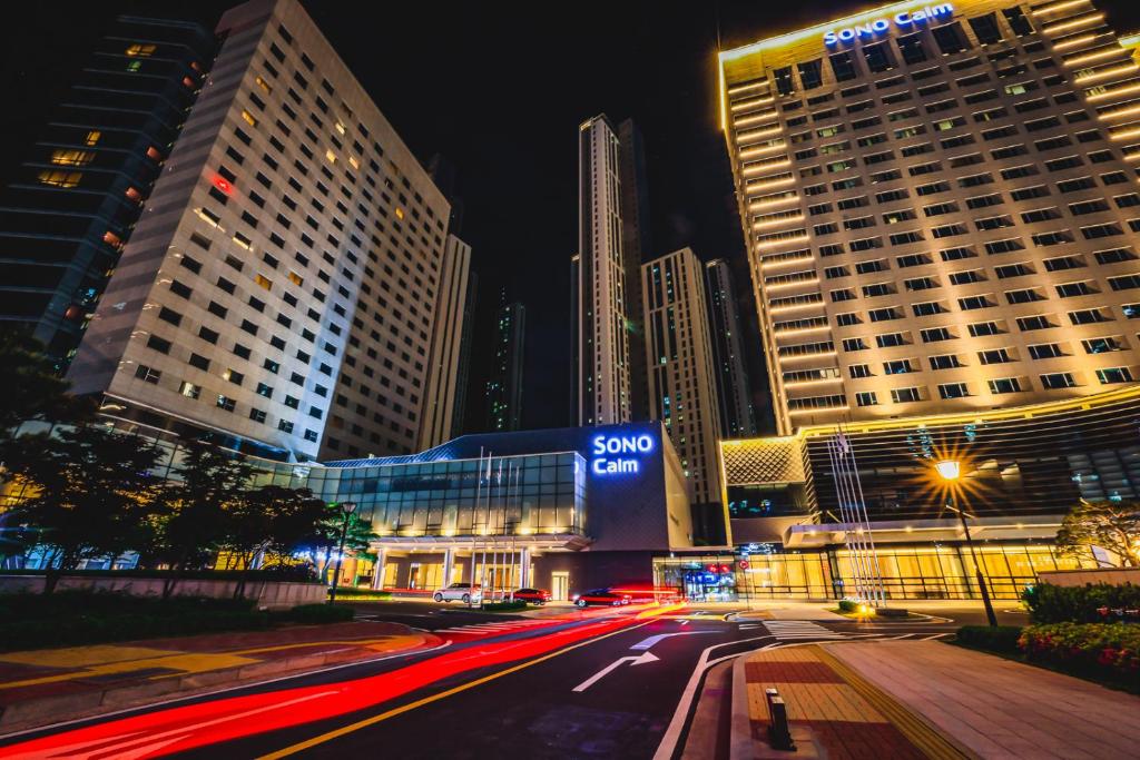 una calle de la ciudad por la noche con edificios altos en Sono Calm Goyang, en Goyang